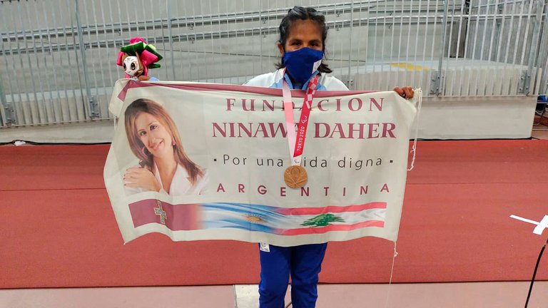 Yanina Martinez con la bandera de la Fundación Ninawa Daher